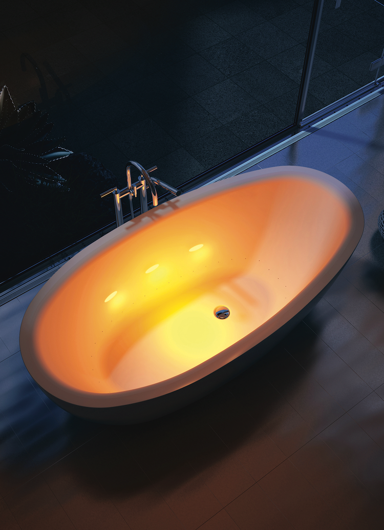 A BainUltra bath illuminated with warm chromatherapy light.
